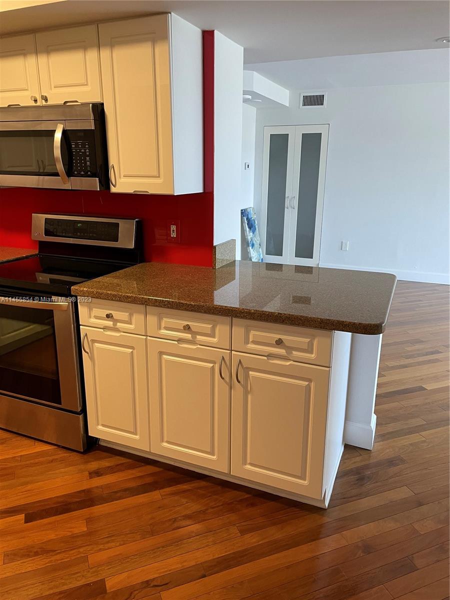 1900 Sunset Harbour Drive, Unit 1209 Miami Beach, FL 33139 - Photo 8 of 35 a kitchen with stainless steel appliances granite countertop a stove a sink and a microwave