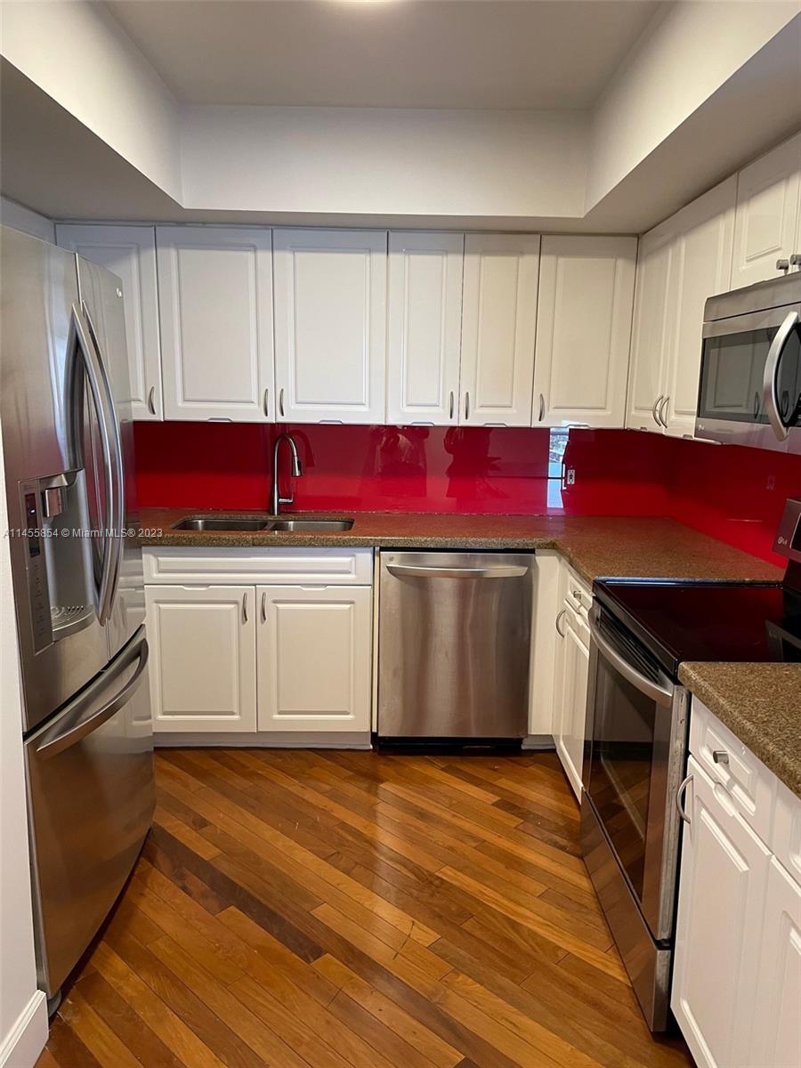 1900 Sunset Harbour Drive, Unit 1209 Miami Beach, FL 33139 - Photo 9 of 35 a kitchen with stainless steel appliances a stove microwave and sink