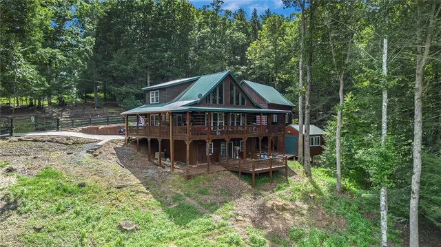 an aerial view of a house with swimming pool next to a yard