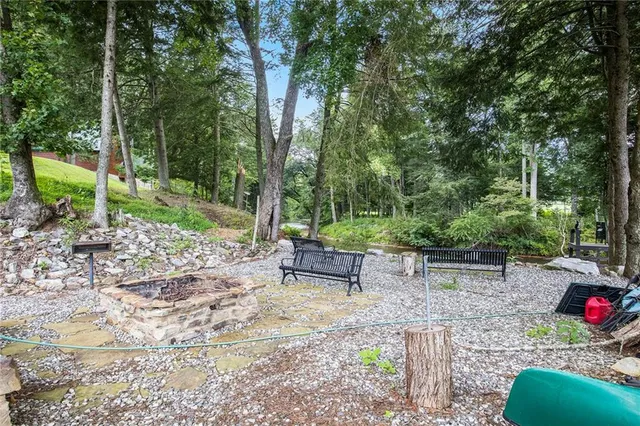 a view of a lake with a bench and trees