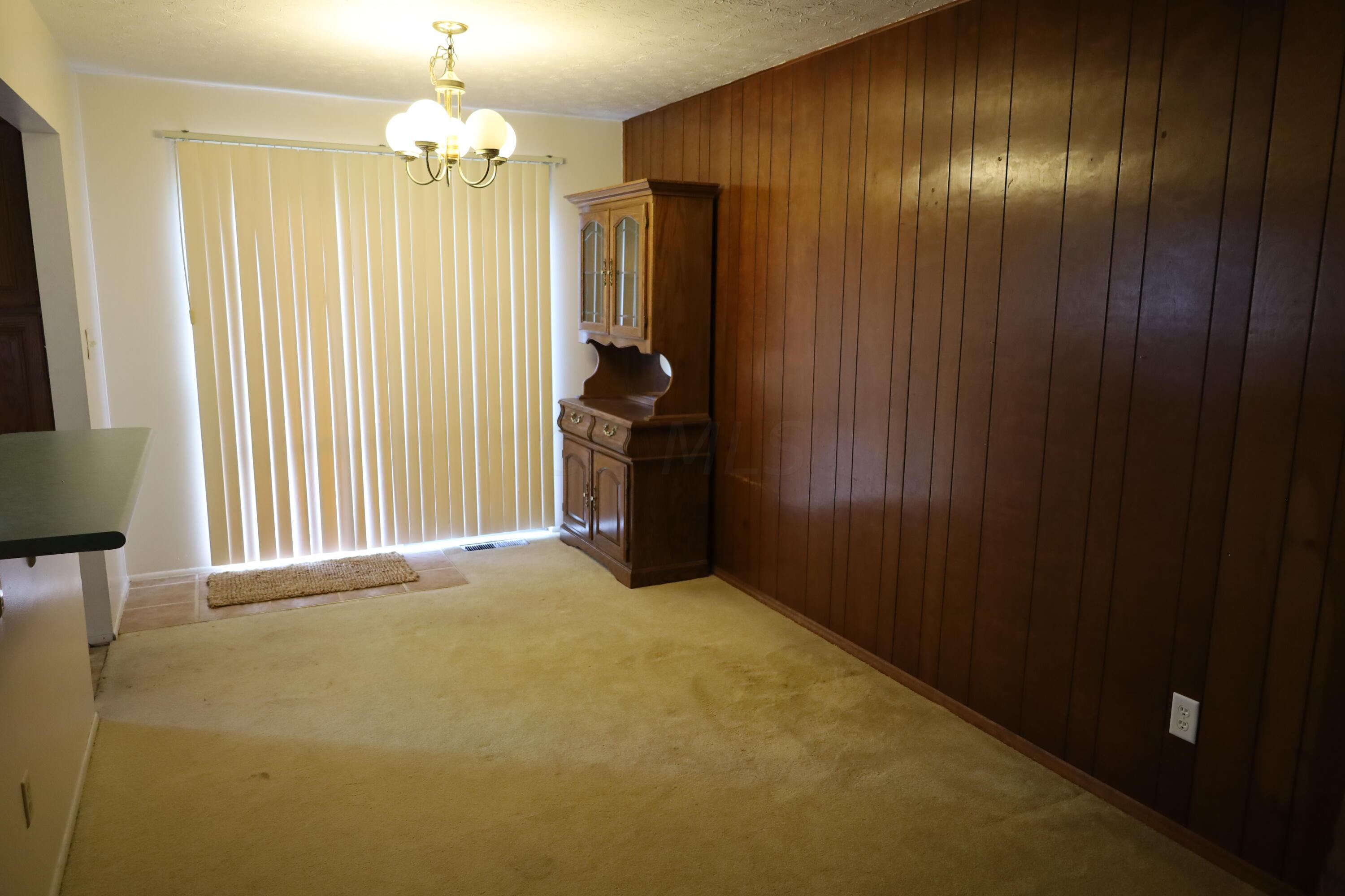 3864 Edendale Road Columbus, OH 43207 - Photo 7 of 24 8'11" x 10'3" - White painted walls, light taupe ceramic tile in entry to back yard, beige carpet, chocolate paneling, light fixture