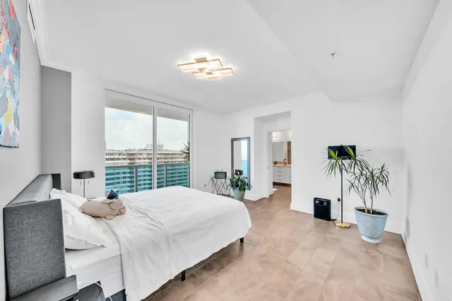 a bedroom with a large bed and a chandelier