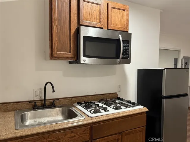 a kitchen with granite countertop stainless steel appliances a sink stove and microwave