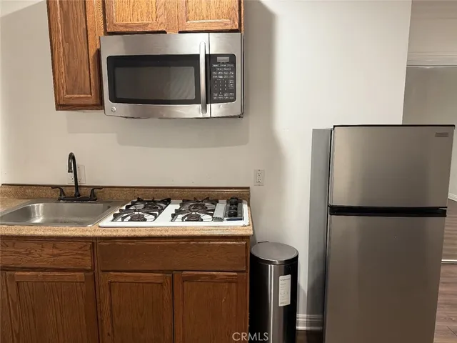 a kitchen with stainless steel appliances granite countertop a refrigerator and a stove top oven