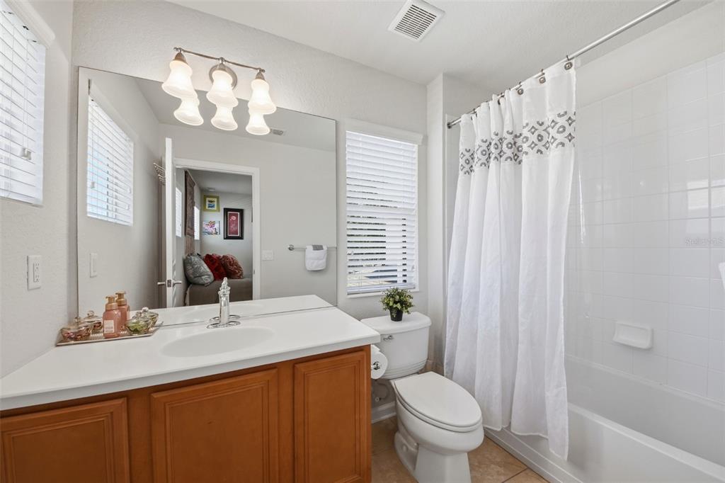 7519 Brofield Avenue Windermere, FL 34786 - Photo 29 of 49 a bathroom with a granite countertop sink a toilet and a mirror