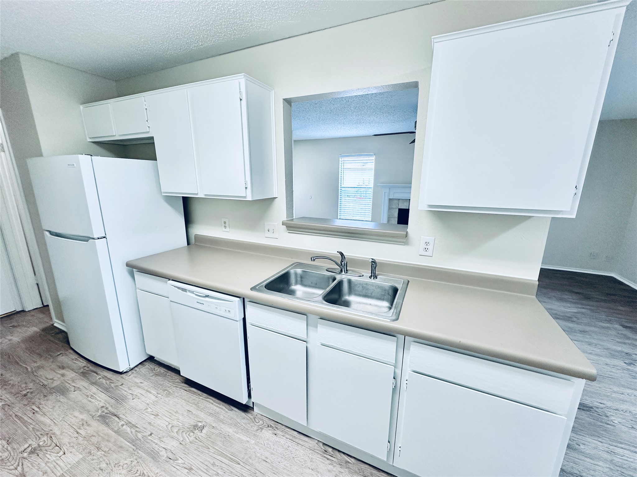379 Fantail Loop, Unit B Austin, TX 78734 - Photo 12 of 33 Crisp white cabinetry paired with matching appliances frames a convenient pass-through to the living space.