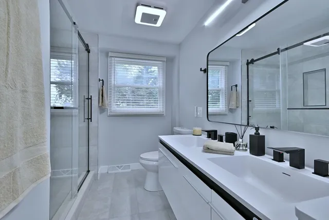 a bathroom with a double vanity sink toilet and shower