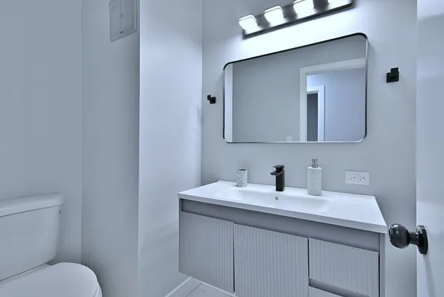 a bathroom with a toilet sink and mirror