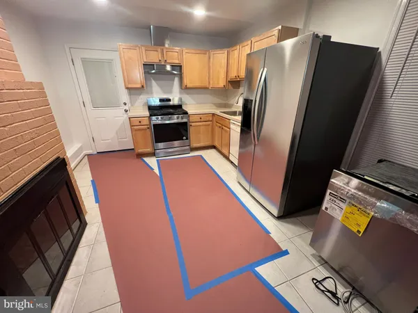 a kitchen with stainless steel appliances granite countertop a refrigerator stove and sink