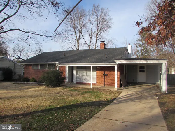 a front view of house with yard and trees around