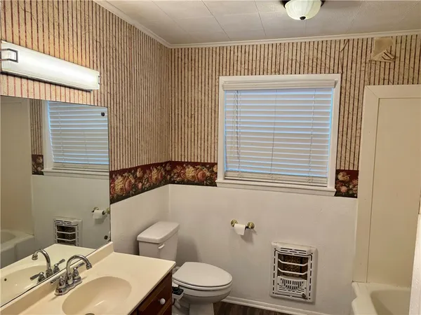 a bathroom with a toilet a sink and a window