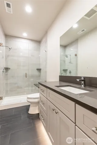 a bathroom with a granite countertop toilet a sink and a bathtub
