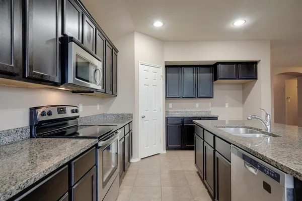 a kitchen with stainless steel appliances granite countertop a sink stove and microwave