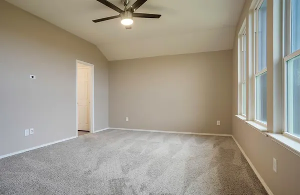 an empty room with chandelier fan