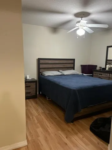 a bedroom with a bed and a ceiling fan