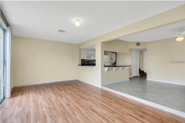 a view of a kitchen with wooden floor and a refrigerator