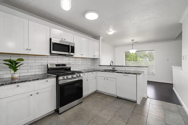 a kitchen with a sink stove and microwave