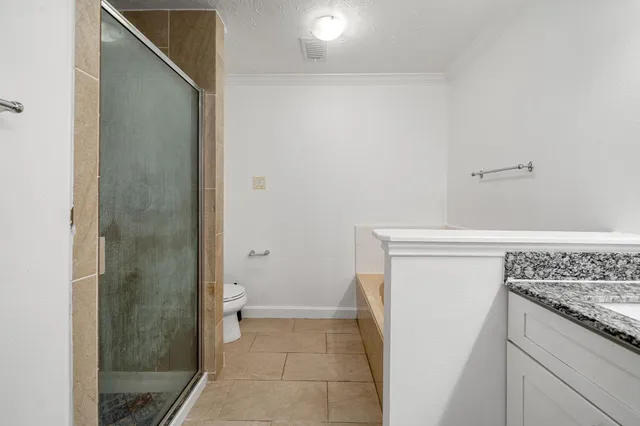 a bathroom with a granite countertop sink and toilet
