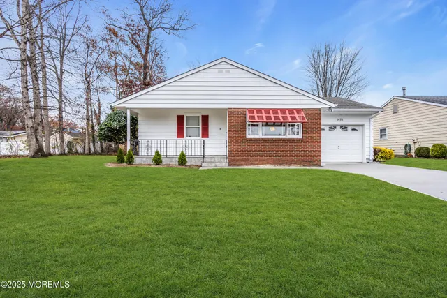 a front view of a house with a garden and yard
