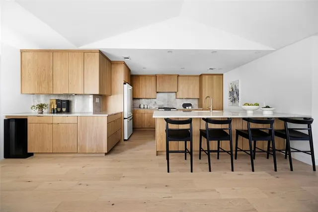 a kitchen with a table chairs sink and cabinets