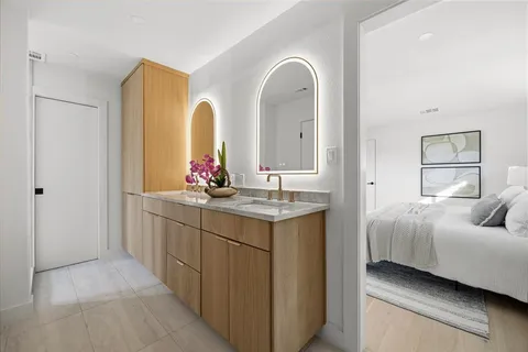 a en suite bathroom with a granite countertop sink and a mirror