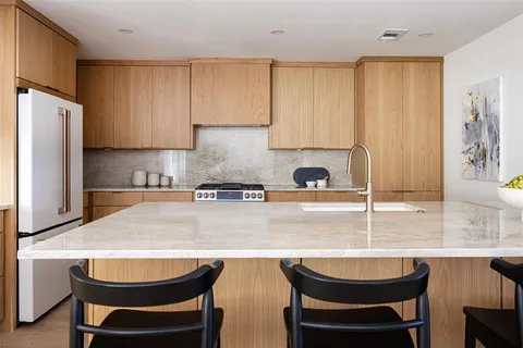 a kitchen with granite countertop a sink stove and refrigerator
