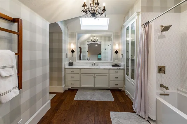 a bathroom with a double vanity sink a large mirror a bathtub and shower