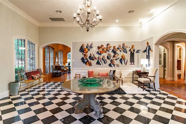 a living room with a black white checkered floor with a gaming machine and dining chairs