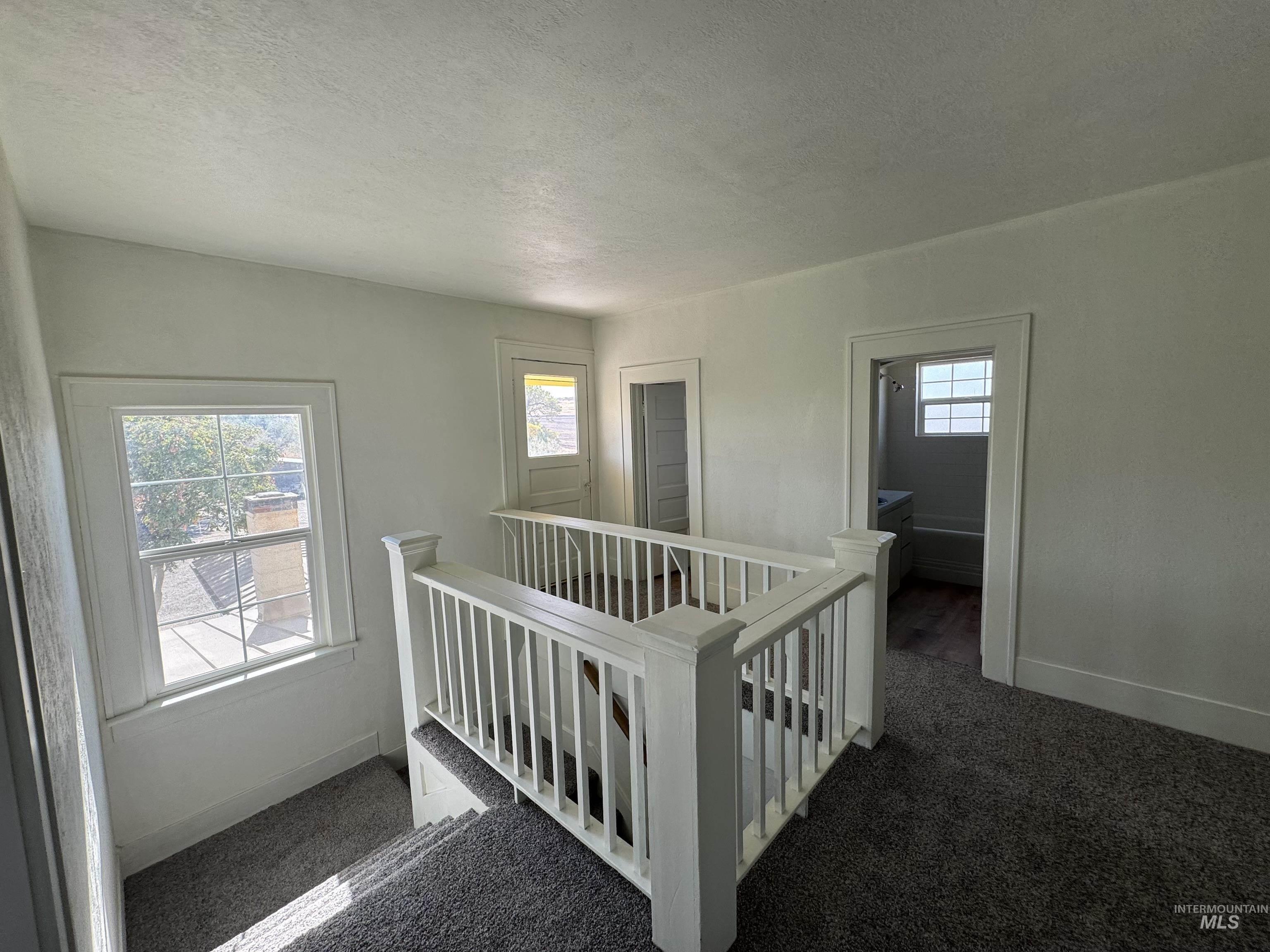 729 Morgan Avenue Ontario, OR 97914 - Photo 31 of 49 Hallway with an upstairs landing, carpet, and a textured ceiling