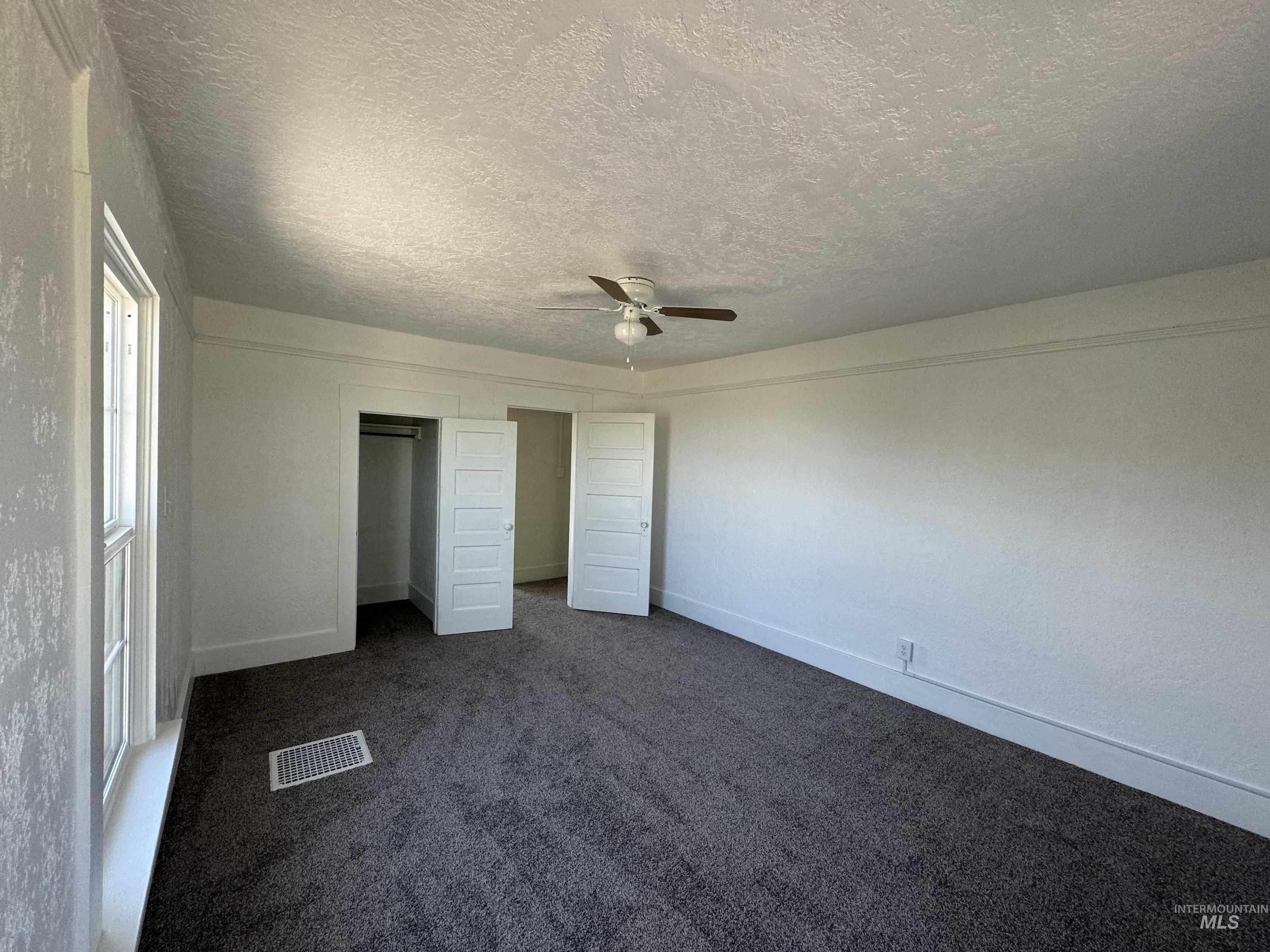 729 Morgan Avenue Ontario, OR 97914 - Photo 44 of 49 Unfurnished bedroom with a textured ceiling, dark colored carpet, and ceiling fan