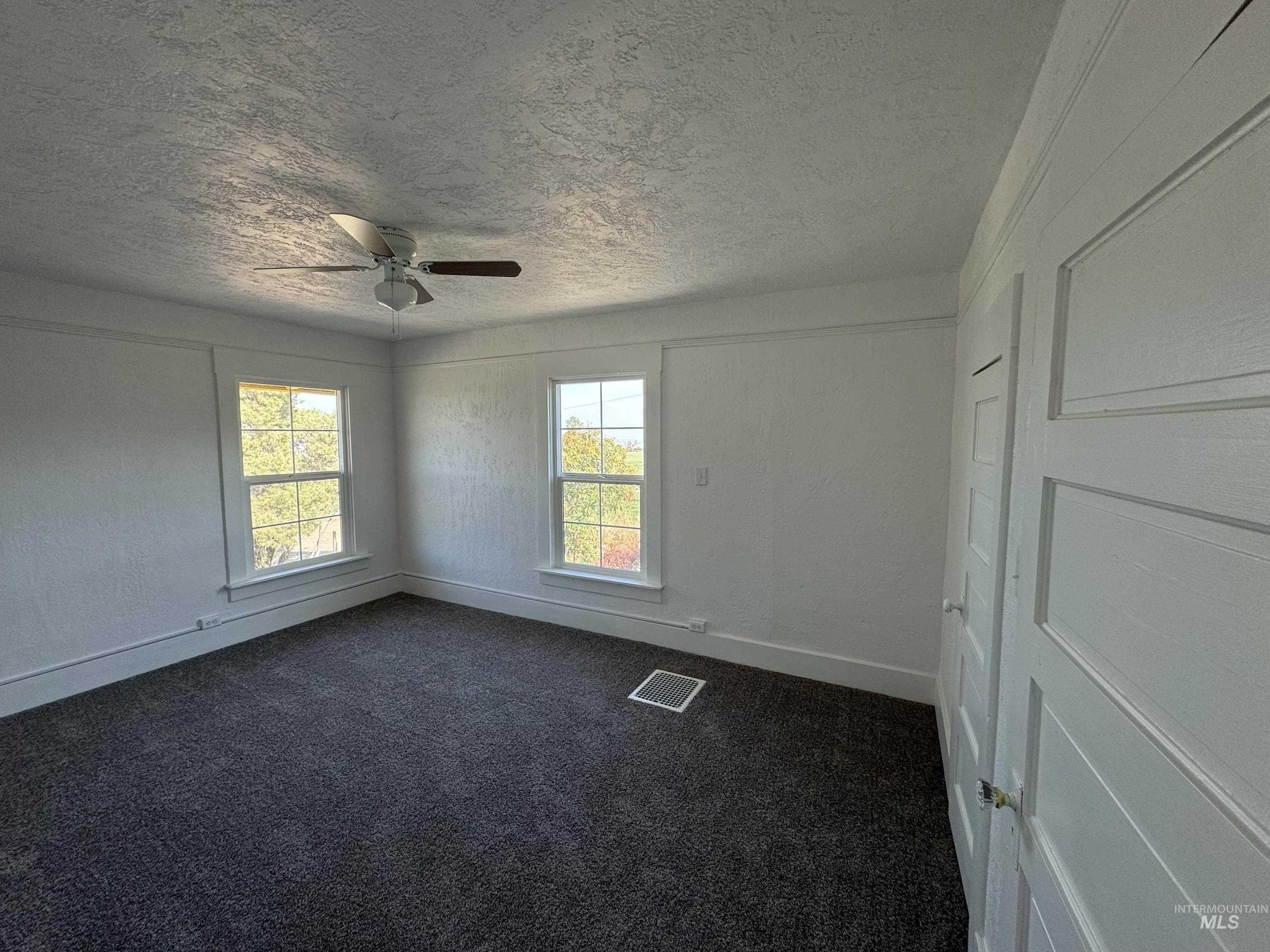 729 Morgan Avenue Ontario, OR 97914 - Photo 46 of 49 Unfurnished room featuring a textured ceiling, dark carpet, and a ceiling fan