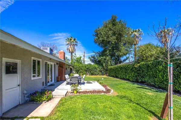a view of a backyard with plants and a patio