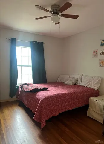 a bedroom with two beds and wooden floor