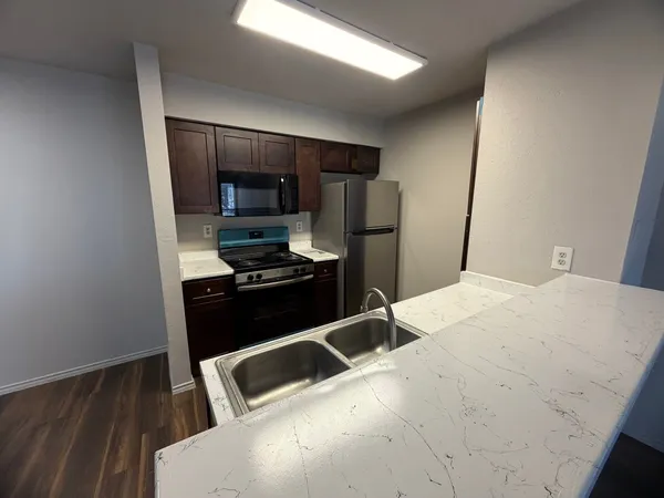 a kitchen with a refrigerator and a stove top oven