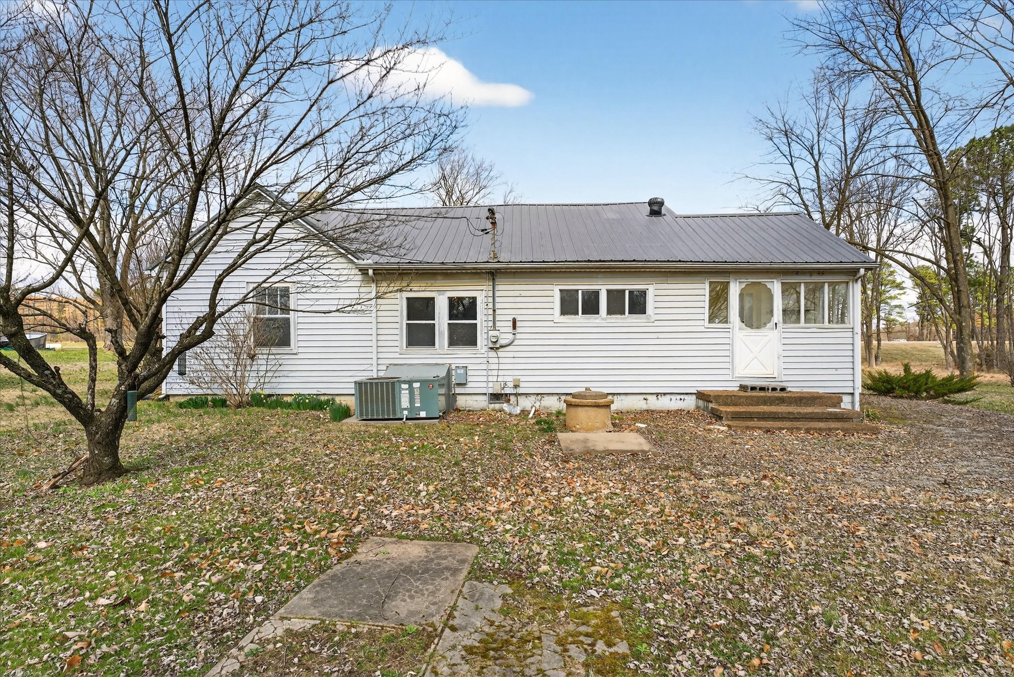 3236 Dover Road Woodlawn, TN 37191 - Photo 20 of 38 a backyard of a house with large trees and barbeque oven