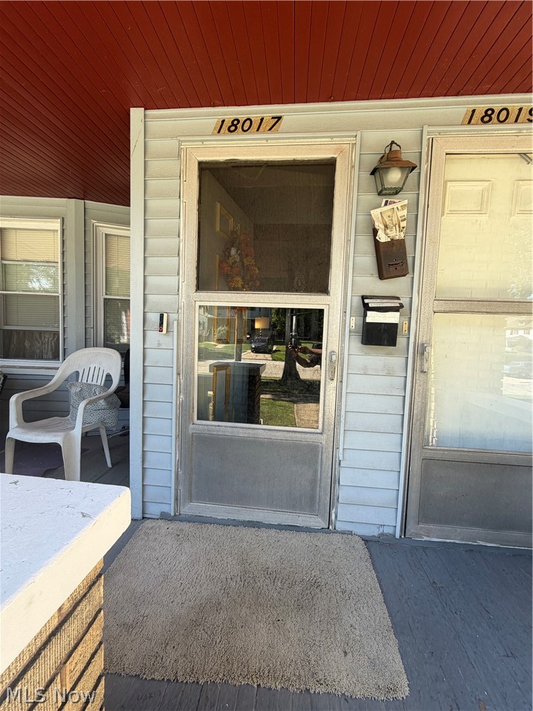 18017 Olympia Road Cleveland, OH 44112 - Photo 2 of 34 Covered porch entrance with light-colored siding, a screen door, and an exterior wall lantern