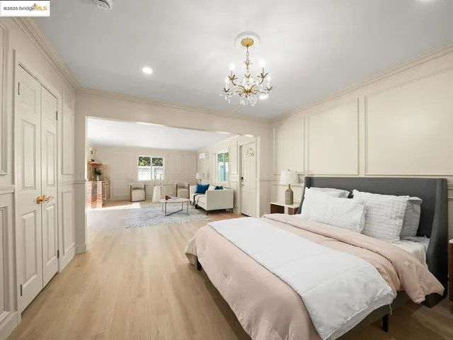 a spacious bedroom with a bed and a chandelier