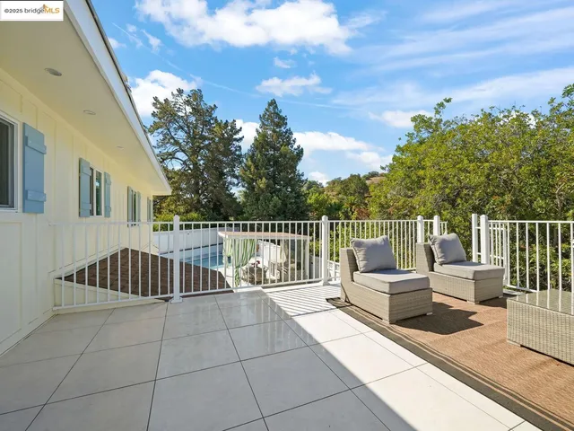 a roof deck with couches and wooden floor