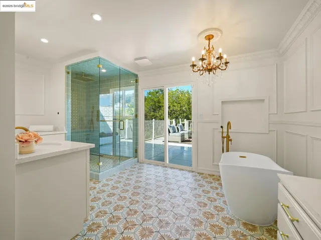 a living room with a baby crib furniture and a chandelier