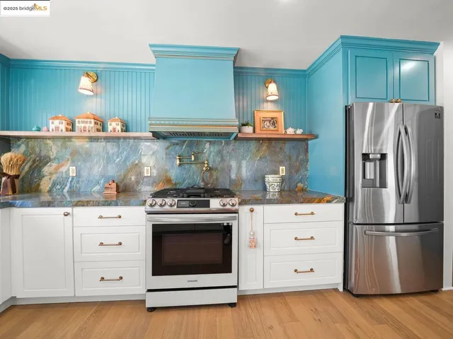 a kitchen with granite countertop a stainless steel stove and refrigerator