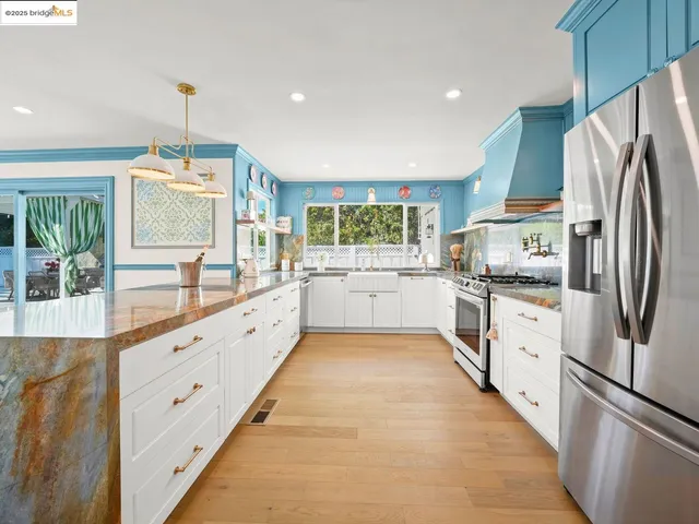 a large white kitchen with a refrigerator a stove a sink and a refrigerator