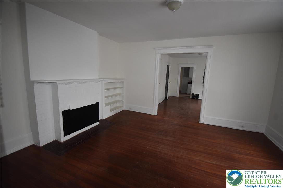312 March Street, Unit 2 Easton, PA 18042 - Photo 3 of 10 a view of an empty room with wooden floor fireplace and a window