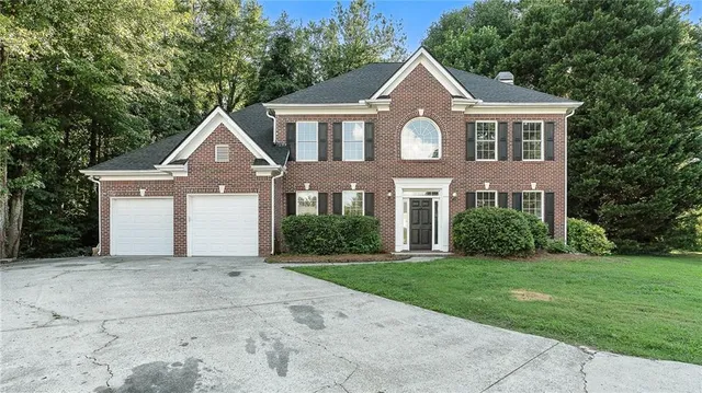 a front view of a house with a yard and garage