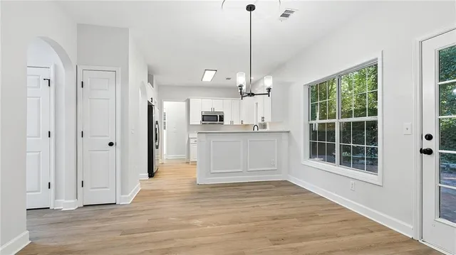 a view of a kitchen with wooden floor and a window