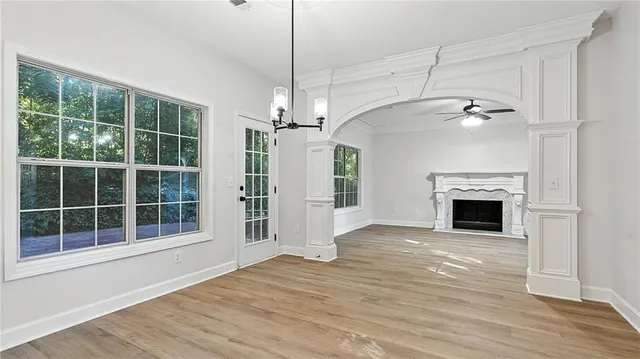 a view of empty room with wooden floor fireplace and windows