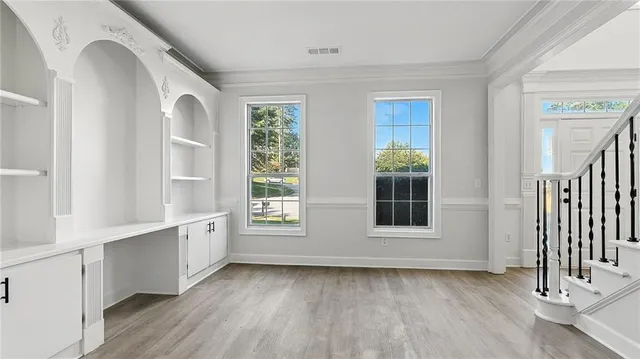 an empty room with wooden floor and windows