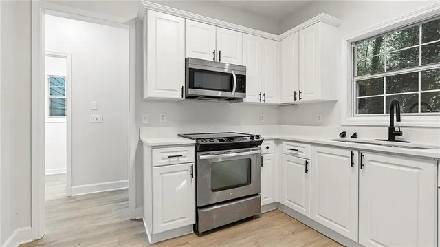 a kitchen with white cabinets and stainless steel appliances