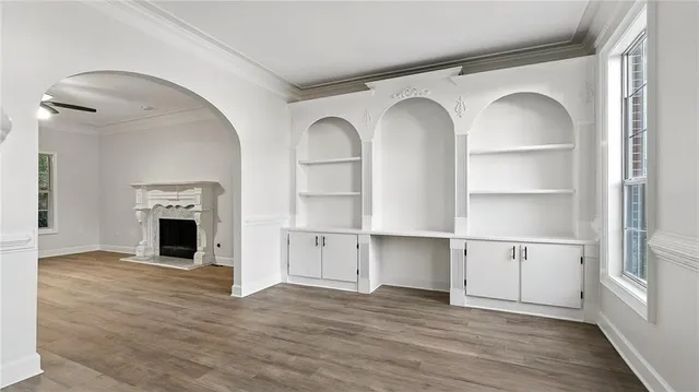 a view of a livingroom with wooden floor and a fireplace