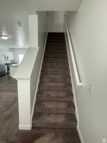 14760 Rising Star Way, Unit 71 Bluffdale, UT 84065 - Photo 21 of 41 Carpeted staircase with a white wall-mounted handrail