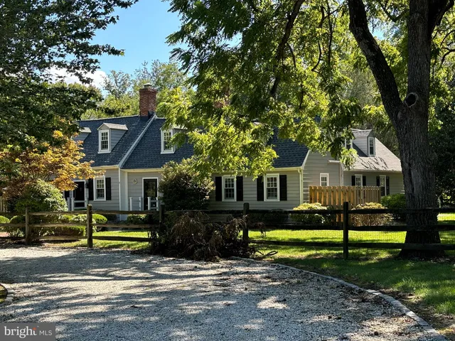 a view of a house with a big yard plants and large trees